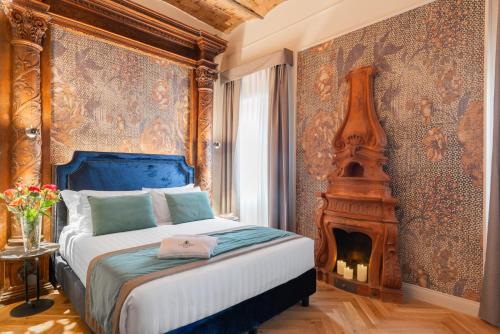 a bedroom with a king sized bed and a fireplace at H77 Apartments - Maison D'Art Collection in Rome