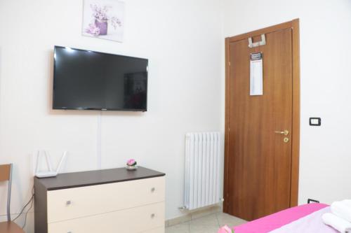a bedroom with a dresser and a tv on the wall at The Maze Vibo B&B in Vibo Valentia
