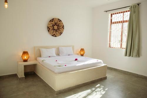 a bedroom with a large bed with a clock on the wall at Paje White House in Paje