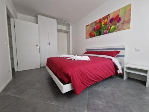 a bedroom with a red bed and a painting on the wall at Iris 2 in Verona