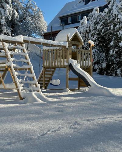 a playground with a slide in the snow at Lieblingsquartier Sankt Andreasberg Studio 9 in Sankt Andreasberg