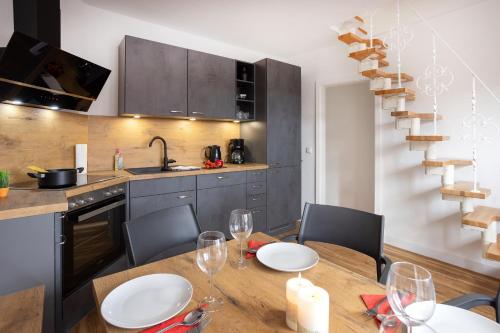 a kitchen with a wooden table with chairs and a dining room at Ferienhaus Brockenoase Apartment Bergzauber in Benneckenstein