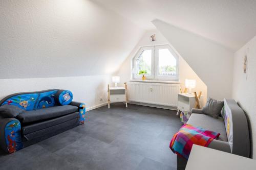 a living room with a couch and a chair at Ferienhaus Brockenoase Apartment Bergzauber in Benneckenstein