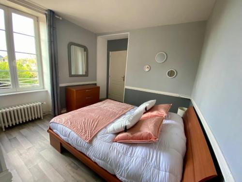 a bedroom with a bed with pillows on it at Clos Minotte 30 pers jacuzzi, billard, baby-foot in Tessy-sur-Vire
