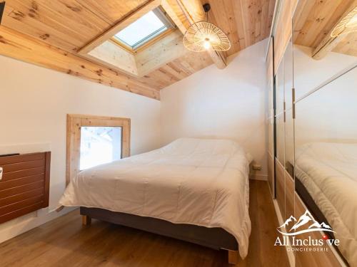 - une chambre avec 2 lits et un plafond avec une fenêtre dans l'établissement Appartement au pied des pistes, à Megève