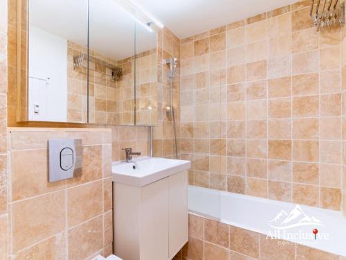 une salle de bain avec un lavabo et une baignoire dans l'établissement Appartement au pied des pistes, à Megève