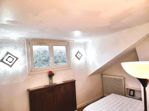 a room with a window and a vase with a flower at Appartement de 60m2 à 20 minutes de Paris in Montigny-lès-Cormeilles