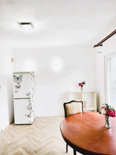a dining room with a table and a refrigerator at Appartement de 60m2 à 20 minutes de Paris in Montigny-lès-Cormeilles