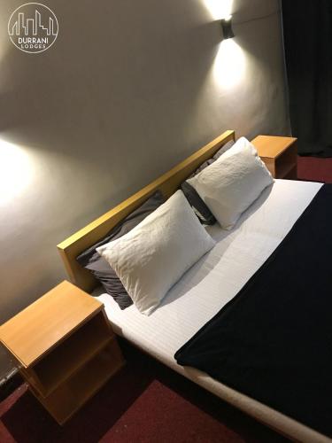 a bed with two pillows on it in a room at Durrani Lodges - G11 Islamabad in Islamabad