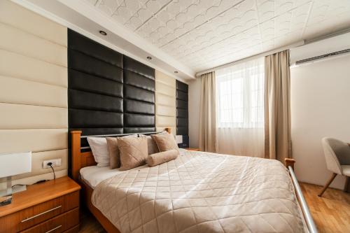 a bedroom with a large bed with a black headboard at F Apartmani Kragujevac in Kragujevac