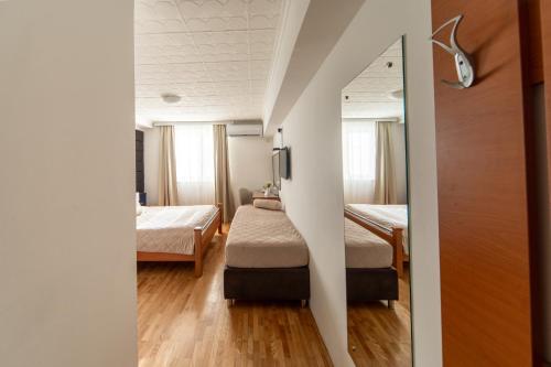 a small room with two beds and a mirror at F Apartmani Kragujevac in Kragujevac