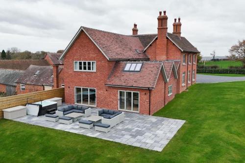 a large brick house with a patio in front of it at Grange House - Sleeps 24 in Alvechurch