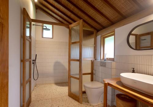 a bathroom with a toilet and a sink at Poolside Room with Lounge in Kaba-Kaba in Tabanan