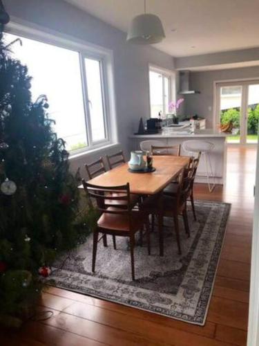 a dining room with a table and a christmas tree at Views for day's in Lyall Bay in Wellington