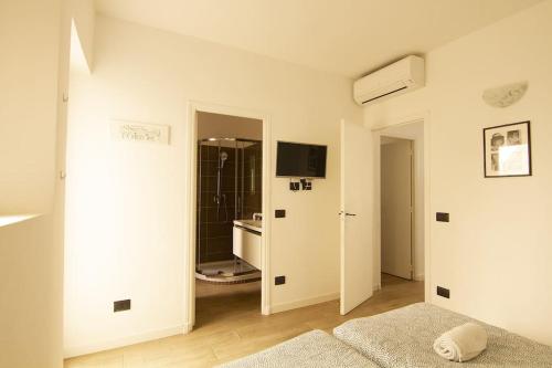 une chambre blanche avec un lit et une télévision dans l'établissement Magnifique T2 au cœur de Cannes, à Cannes