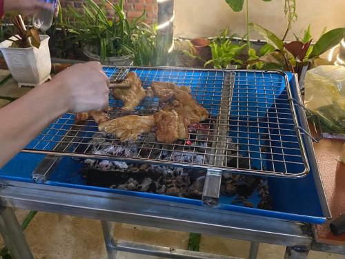 a person is cooking food on a grill at Đại Ngàn Homestay in Kon Von Kla