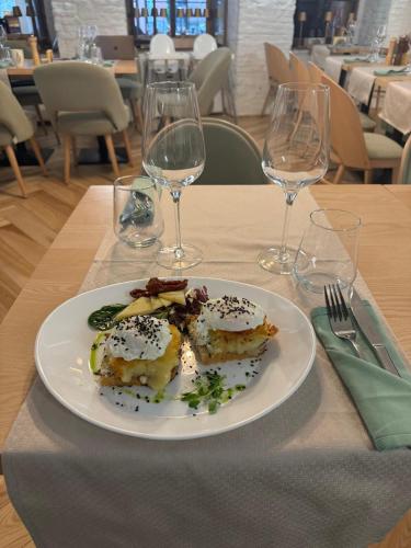 een bord eten op tafel met wijnglazen bij Barrique Apartament in Braşov