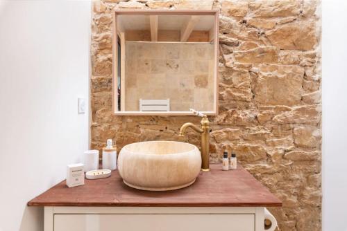 La salle de bains est pourvue d'un grand lavabo et d'un mur en pierre. dans l'établissement Le Cocon de Saint-Jean, à Lyon