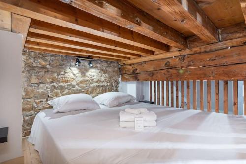 une chambre avec un lit blanc avec des serviettes dessus dans l'établissement Le Cocon de Saint-Jean, à Lyon