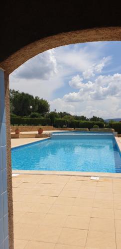 - une vue sur la piscine à travers une arche dans l'établissement Petite maison en Ardèche, à Saint-Martin-dʼArdèche