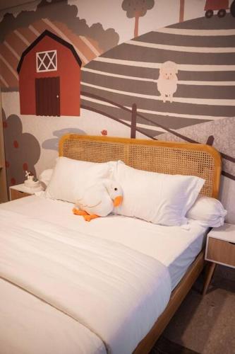 a bed with a stuffed bird sitting on top of it at Little Barn by Little Bnb in Jakarta