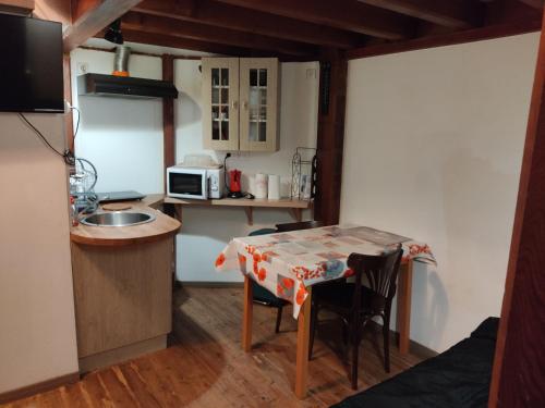 una piccola cucina con tavolo, sedie e forno a microonde di Studio la Nuit au Coeur de ville a Limoux