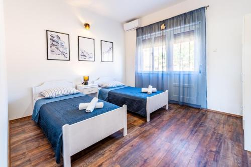 a bedroom with two beds and a window at Holiday house Nada with the pool in Fažana