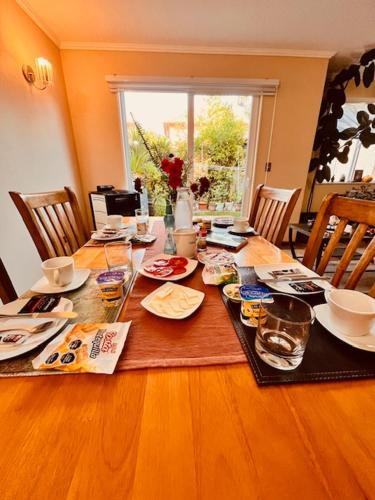 a dining room table with plates and dishes on it at Hostal Hostal in Los Ángeles