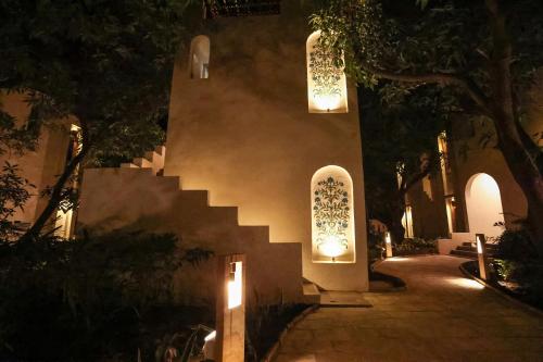 a building with lights and a staircase at night at Le Casa Lion Resort A Premium Resort In Sasan Gir in Sasan Gir