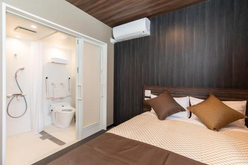 a bedroom with a bed and a bathroom with a shower at The Celecton Fujisan Gotemba Interchange in Gotemba