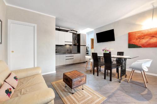 a living room with a couch and a table with chairs at Appartamento Piccolo Principe in Moniga