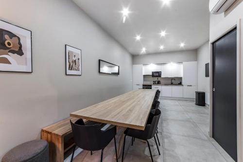a dining room with a wooden table and chairs at MAISON LE GRATTE CIEL - séminaire ou famille, salle de réunion, 8 chambres Clim, Jardin & Salle de sport in Villeurbanne