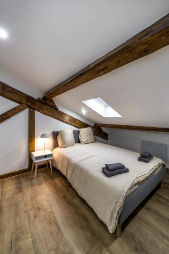 une chambre avec un grand lit dans un grenier dans l'établissement MAISON LE GRATTE CIEL - séminaire ou famille, salle de réunion, 8 chambres Clim, Jardin & Salle de sport, à Villeurbanne