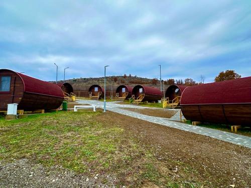 a group of wooden buildings with red roofs at Eco Camp Lake Mladost in Veles