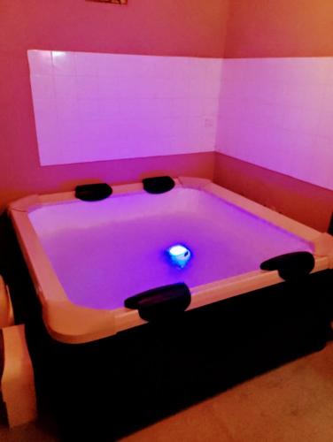 a pool table in a room with purple lighting at Spa suite Parma in Parma
