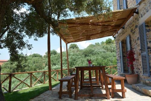 a wooden table and two benches on a patio at Casolare Cento Ulivi Luxury & Charme - Villa exclusive use in Ascea