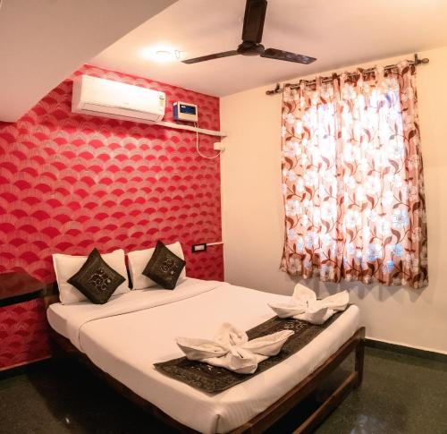 a bedroom with a bed with a red wall at House Of Brothers in Arambol