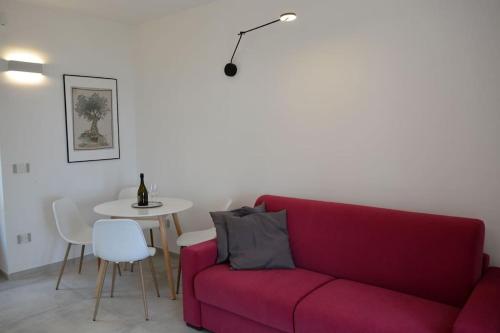 a living room with a red couch and a table at Casolare Cento Ulivi Luxury & Charme - Villa exclusive use in Ascea