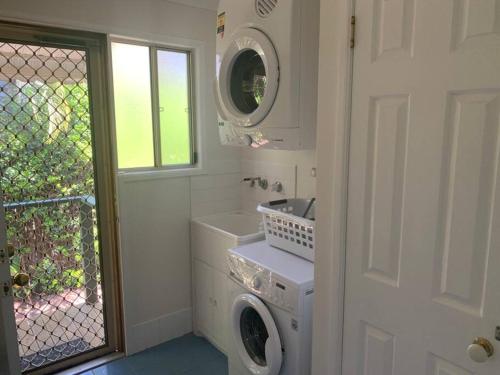 a white laundry room with a washer and dryer at NORTH BYRON BEACH HOUSE Surf Sun Sand in South Golden Beach