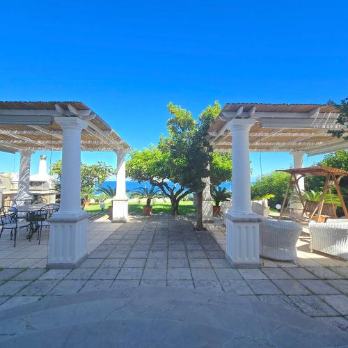 a pavillion with white columns and tables and chairs at La Spiga in Capri