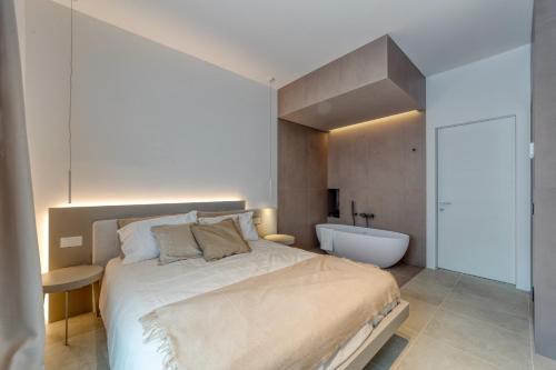 a bedroom with a large bed and a bath tub at Santa Lucia Suites in Padova