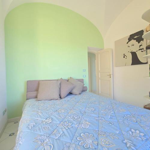 a bedroom with a bed with a blue comforter at La Spiga in Capri