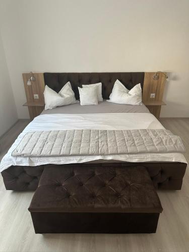 a large bed with white sheets and pillows at Aparthouse 1 in Lugoj