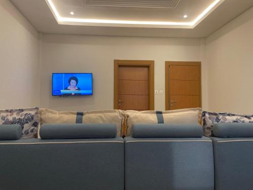 a large couch in a room with a tv on the wall at Seven Heaven Plaza in Serekunda