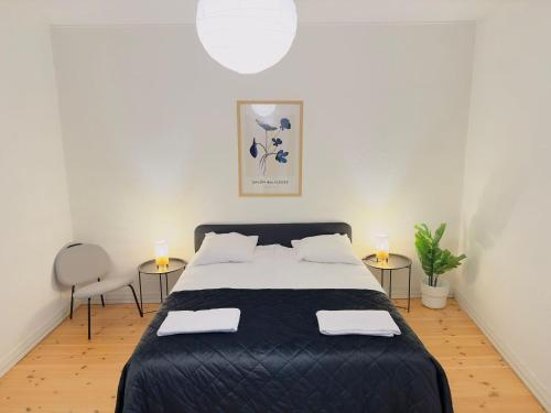 オールボーにあるaday - Central Charming 2 bedrooms Apartmentのベッドルーム1室(大型ベッド1台、テーブル2台付)