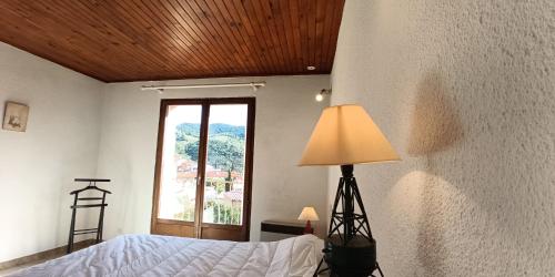 une chambre avec un lit, une lampe et une fenêtre dans l'établissement Maison familiale au calme, à Banyuls-sur-Mer