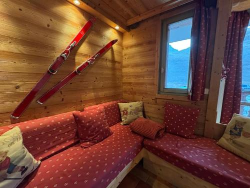 - un canapé dans une cabine avec des skis sur le mur dans l'établissement RPP B124 - Apt 6pers - pied des pistes, à Tignes