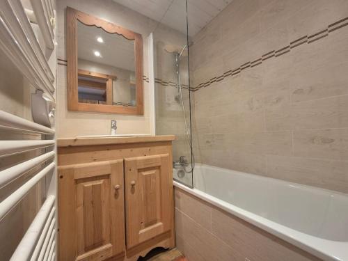 une salle de bain avec un lavabo, une baignoire et un miroir dans l'établissement RPP B124 - Apt 6pers - pied des pistes, à Tignes