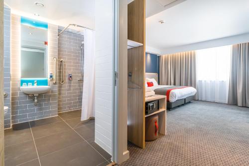 a hotel room with a bed and a bathroom at Holiday Inn Express - Bodmin - Victoria Junction by IHG in Bodmin