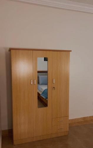 a wooden cabinet with a mirror in a room at MAG Palace Hotel in Bissau